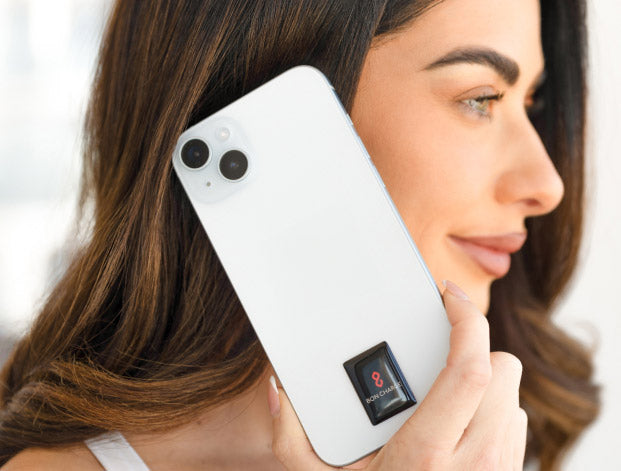 Woman holding phone up to ear with EMF sticker on device