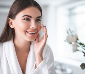 Woman looking in mirror at clear skin