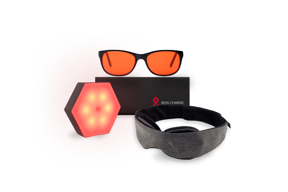 Blue Light blocking glasses on top of black case, next to a sleep mask and motion sensor night light