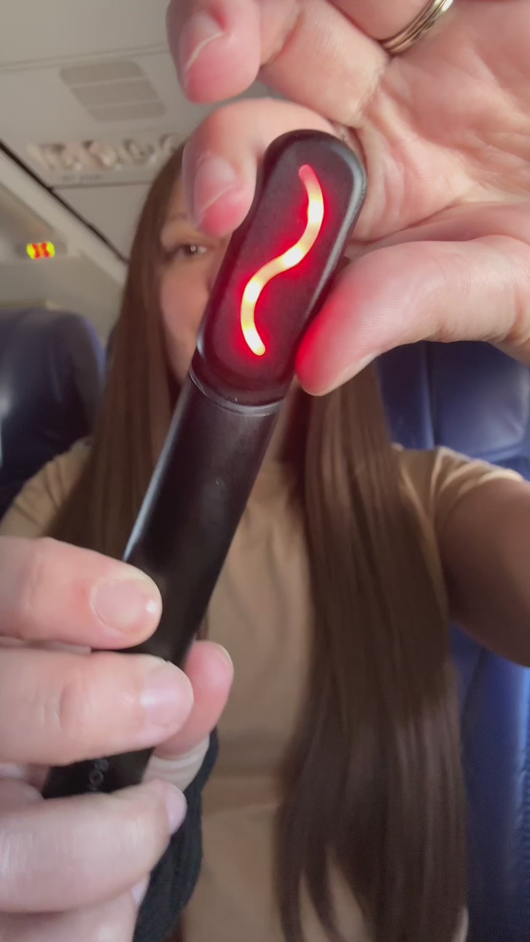 Woman using Face Wand while on flight